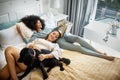 Dog, bed and happy lesbian couple in home, morning and relax together reading book. Pet, bedroom and gay women with Royalty Free Stock Photo