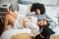 Dog, bedroom and lesbian couple smile in home, morning and relax together. Pet, bed and happy gay women with animal Royalty Free Stock Photo