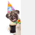 Dog in birthday hat holding beer peeking from behind empty board. isolated Royalty Free Stock Photo