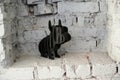 Dog figure on white brick background filmed horizontally