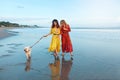 Dog-Friendly Beach. Women In Boho Dress With Dog On Coast. Silhouette Reflection And Footprints On Wet Sand Royalty Free Stock Photo