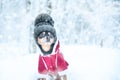 Dog in a funny knitted hat with a huge pumpon in the winter forest, a space for text, Concept  warm clothes for dogs Royalty Free Stock Photo