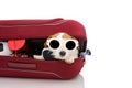 DOG INSIDE A RED MODERN BAGGAGE OR LUGGAGE GOING ON VACATIONS WEARING SUNGLASSES. ISOLATED AGAINST WHITE BACKGROUND Royalty Free Stock Photo