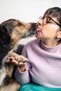 Dog kissing and giving paw to his owner, a Latin American woman Royalty Free Stock Photo