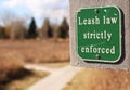 Dog leash law sign along walking path Royalty Free Stock Photo