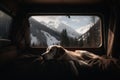 A dog lying on cozy bed inside of camper van with view on mountains. Generative ai