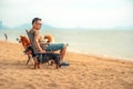 Dog owner sitting on a chair on the beach and see sunset Royalty Free Stock Photo