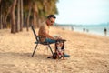 Dog owner sitting on a chair on the beach and see sunset Royalty Free Stock Photo