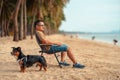 Dog owner sitting on a chair on the beach and see sunset Royalty Free Stock Photo