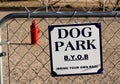 Dog park bring your own poop bag on fence and fire hydrant.