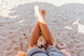 Dog`s face between the legs of a man laying on the sunbed Royalty Free Stock Photo
