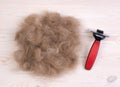 Dog`s hair and a pet comb with scissors on a wooden background after trimming a dog Royalty Free Stock Photo