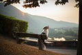 The dog sits on a bench and looks at the dawn. Marble australian shepherd in nature. Walk Royalty Free Stock Photo