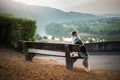 The dog sits on a bench and looks at the dawn. Marble australian shepherd in nature. Walk Royalty Free Stock Photo