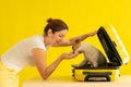 Dog is sitting in a suitcase next to a laughing woman on a yellow background. The girl is going on a trip with a pet Royalty Free Stock Photo