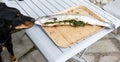 A dog sniffs a salmon stuffed with herbs