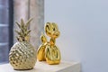 Luxury golden dog statue and golden pineapple on blurred background, funny puppy, interior decoration.Chinese new year Royalty Free Stock Photo