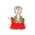 The dog symbol of the year on a Chinese horoscope, sits on a large bag with gift boxes. Cheerful puppy smiles. Decor gold tinsel. Royalty Free Stock Photo