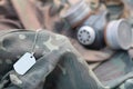 Dog tag with stalker soldiers soviet gas mask lies on green khaki camouflage jackets Royalty Free Stock Photo