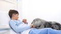 Dog therapy, llonely and sick child lying in hospital bed is cheered by the happiness of the dog