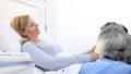 Dog therapy, lonely and sick woman lying in hospital bed is cheered by the happiness of the dog