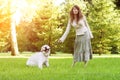 Dog training. Girl with retriever playing in the park. Woman walking a pet on a background summer The landscape. Joyful summer sc