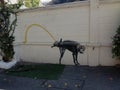 Dog urinating against a wall graffiti in Bangkok Thailand Royalty Free Stock Photo