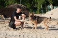 Dog on a walk with the owner in the summer. Walk with a loyal friend of the German Shepherd. Summer evening on a walk with a frien