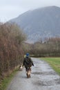 A dog walker with her dogs at Loweswater Lake in The Lakes District, Cumbria in the UK