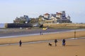 Dog walkers on sand beach