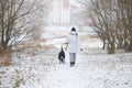 Dog walks on a leash girl in winter. Royalty Free Stock Photo