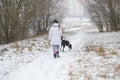 Dog walks on a leash girl in winter. Royalty Free Stock Photo