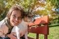 dog and young teenage girl sitting on bench in park in embrace Royalty Free Stock Photo