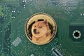 Doge coin on green circuit board,
