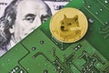 Dogecoin on computer motherboard surface and us dollar bill