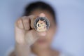 Dogecoin DOGE included with Cryptocurrency on hand working asian women holding coin in front face Filed and put and give to me.