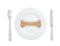 Dogs food bone on a plate with fork and knife isolated on white