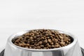 Dogs' food in metal a plate. Dry animal feed in a bowl close up. Dry food for puppies or dogs in a small bowl. Pets