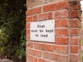 A dogs must be kept of lead white and black simple sign nailed t
