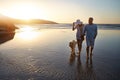 Dogs were not made to sit around all day. a mature couple spending the day at the beach with their dog.