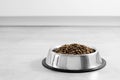 Dogs' food in metal a plate. Dry animal feed in a bowl close up. Dry food for puppies or dogs in a small bowl. Pets