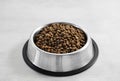 Dogs' food in metal a plate. Dry animal feed in a bowl close up. Dry food for puppies or dogs in a small bowl. Pets