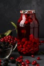 Dogwood compote with blackberry in jar on a dark background, vertical orientation