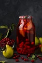 Dogwood compote with pears in jar on a dark background, vertical orientation