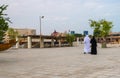 Doha, Qatar - Nov 20. 2019. Man and a woman in national clothes are walking along embankment in Katara Beach Royalty Free Stock Photo