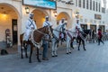 Doha, Qatar - Oct 17, 2022: Tourist police in traditional Qatari dress patrolling along the walkway in Souq Wakif.