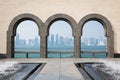 Doha skyline through the arches of the Museum of Islamic art. Royalty Free Stock Photo