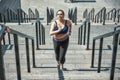 Doing all my best. Active plus size woman in sports clothing running up the stairs while exercising outdoors Royalty Free Stock Photo