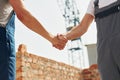 Doing handshake. Two construction workers is together at the building Royalty Free Stock Photo