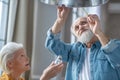 Couple of seniors changing a lightbulb together